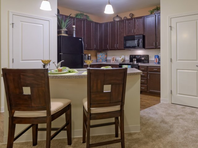 Gourmet preparation island with breakfast bar, pendant lighting and tile backsplashes